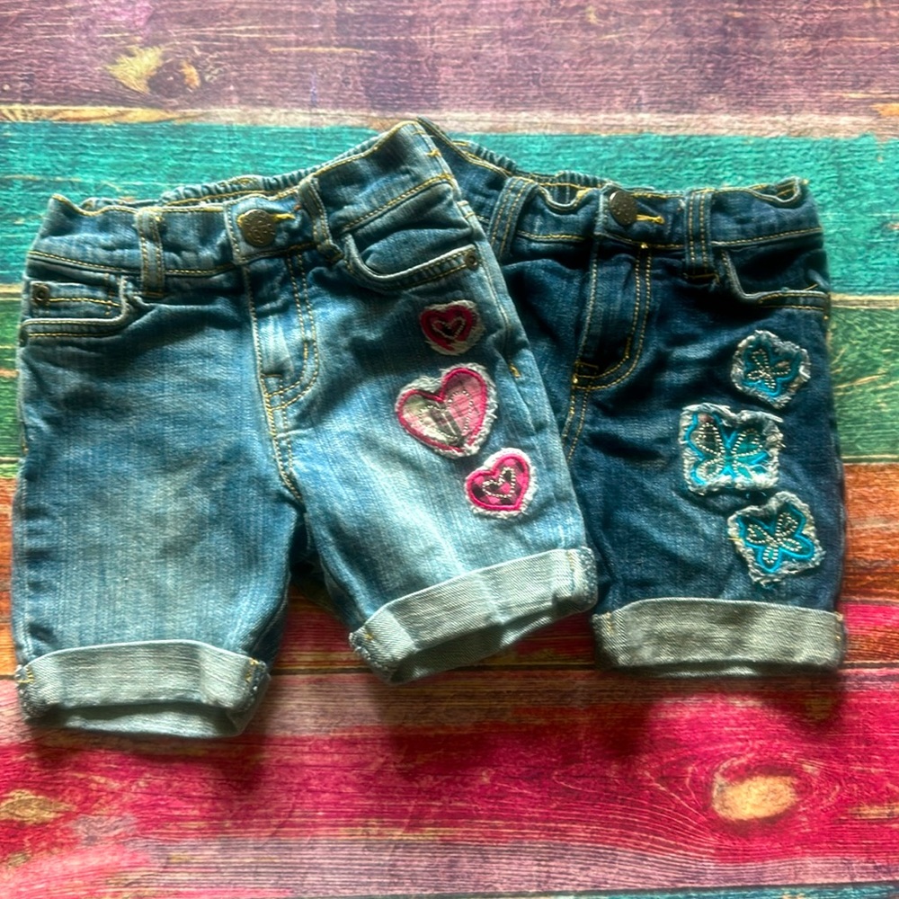 Two pairs of Children’s Place denim Bermuda shorts with appliqués, size 18m
